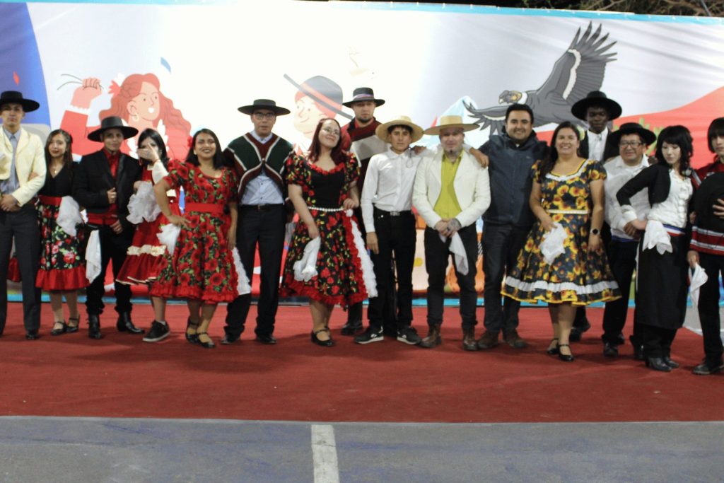 Elenco de la Fiesta de la Chilenidad con trajes de huaso y de china en el escenario