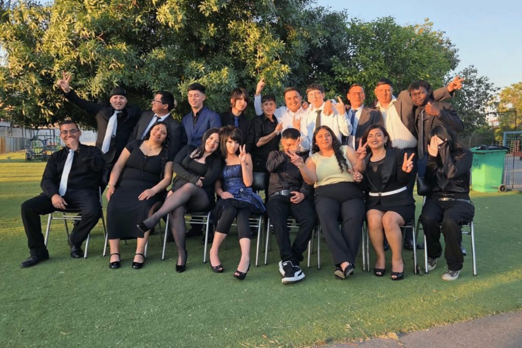 Curso de egresados posando en el jardín el día de la licenciatura